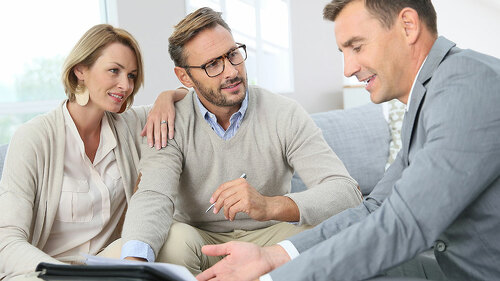 Couple with realtor signing mortgage contract