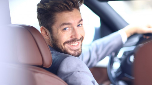 Portrait of an handsome smiling business man driving his car