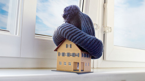 house in winter - heating system concept and cold snowy weather with model of a house