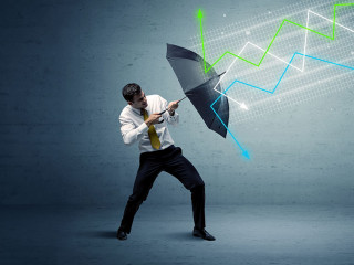 Business person with umbrella and stock market arrows concept