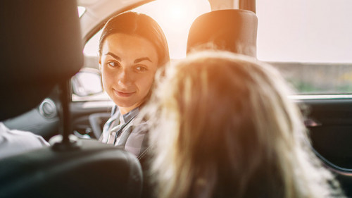 Happy family on a road trip in their car. Dad, mom and daughter are traveling by the sea or the ocean or the river. Summer ride by automobile