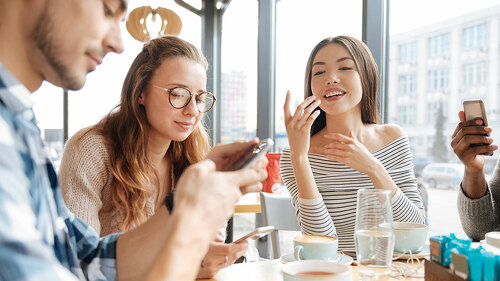 Friends using smartphones in the cafe