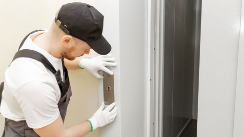 Lift machinist man repairing elevator fixing or adjusting mechanism