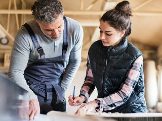 Man and woman workers working in the carpentry workshop.