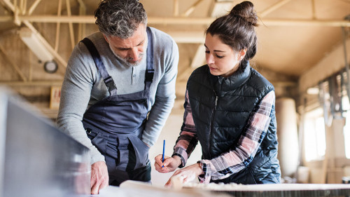 Man and woman workers working in the carpentry workshop.