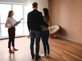 Real estate agent showing young couple a new house