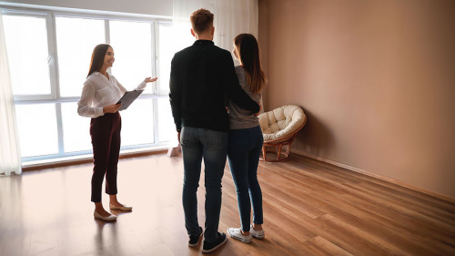 Real estate agent showing young couple a new house