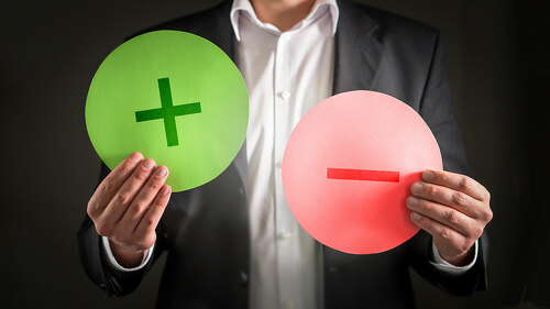 Pros and cons concept. Business man with cardboard plus and minu