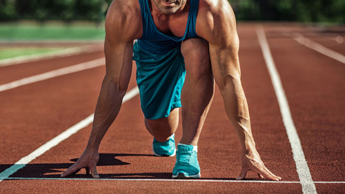 young muscular athlete is at the start of the treadmill