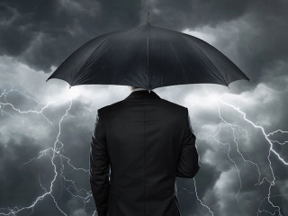 Trouble ahead, Businessman with umbrella standing in front of st