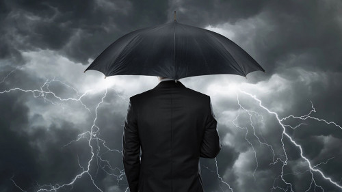 Trouble ahead, Businessman with umbrella standing in front of st