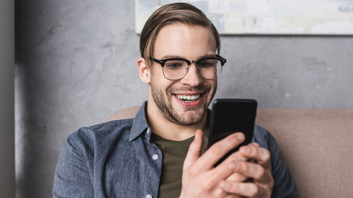 Mann-Smartphone-Laecheln-184220094-DP-SarkisSeysian