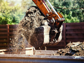 industrial backhoe excavator moving earth on construction site