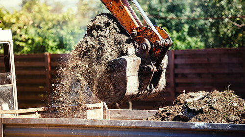 industrial backhoe excavator moving earth on construction site