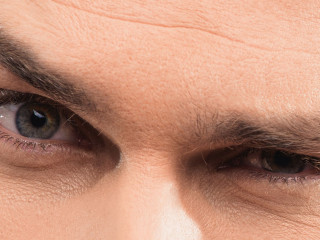 Mistrustful young man scrutinizing someone