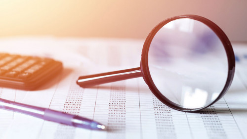 Single Magnifying Glass with Black Handle, Leaning on the financial data. Business and Finance concept,