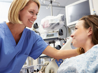 Young Female Patient Talking To Nurse In Emergency Room