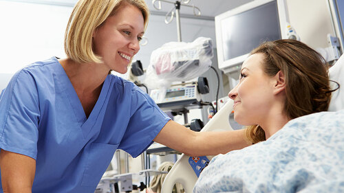 Young Female Patient Talking To Nurse In Emergency Room