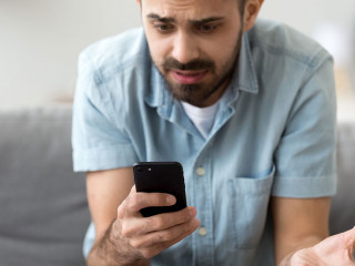 Close up confused man having problem with phone, receive bad news