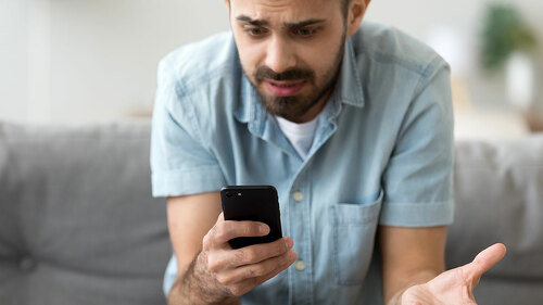 Close up confused man having problem with phone, receive bad news