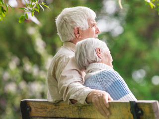 Elderly couple resting on a bench in the park