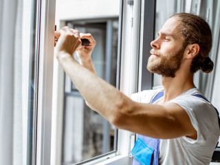 Workman adjusting window frames at home