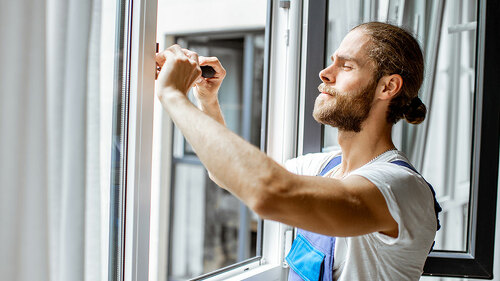 Workman adjusting window frames at home