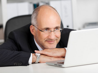 entspannter geschäftsmann liest am laptop