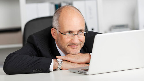 entspannter geschäftsmann liest am laptop