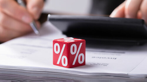 Businessperson Calculating Invoice With Calculator