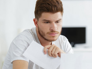 shocked man holding some documents on sofa livingroom
