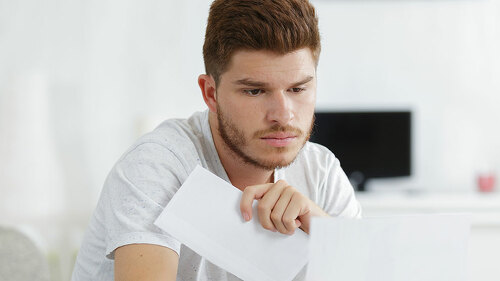 shocked man holding some documents on sofa livingroom
