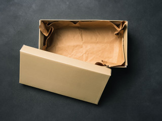 Open empty box with a lid, isolated on a black background. Cardboard box for shoes or gift. Top view, flat layout