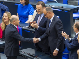 2. Sitzung des 21. Deutschen Bundestages - Kanzlerwahl: Bundeskanzler a.D. Olaf Scholz (2vl), SPD, MdB, gratuliert Bundeskanzler Friedrich Merz (2vr), CDU/CSU, MdB, zur Wahl.