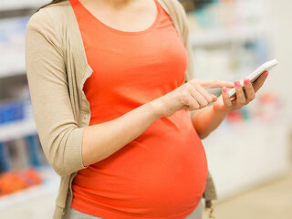 schwangere-tippt-handy-91345491-FO-Syda-Productions