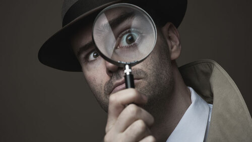 inspektor-mit-lupe-und-hut-79310709-FO-StockPhotoPro