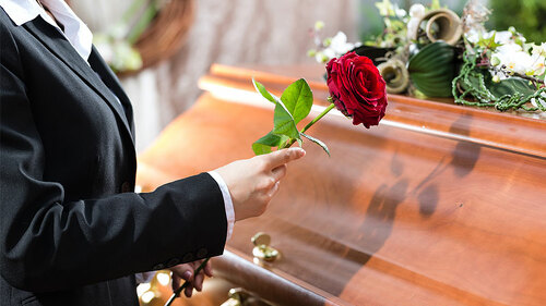 frau-legt-rose-auf-sarg-53545146-FO-Kzenon