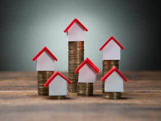 haeuser-auf-muenzen-hoch-niedrig-102564111-FO-Andrey-Popov