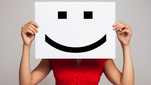 Frau-mit-Smiley-Schild-vor-Kopf-55377811-FO-Minerva-Studio