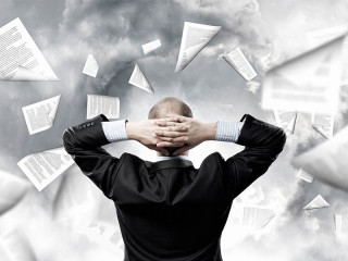 Anzugtraeger-unbeeindruckt-vor-Papiersturm-87246610-FO-Sergey-Nivens