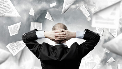 Anzugtraeger-unbeeindruckt-vor-Papiersturm-87246610-FO-Sergey-Nivens