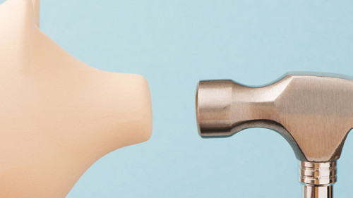 Sparschwein-Auge-inAuge-mit-Hammer-97118018-FO-larshallstrom