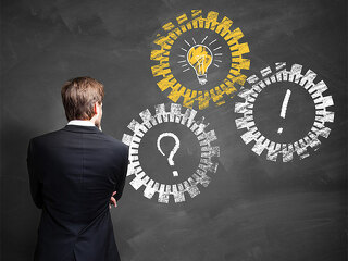 Anzugtraeger-vor-Zahnraeder-auf-Tafel-82412830-FO-fotogestoeber