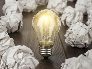 Gluehbirne-zwischen-zerknuelltem-Papier-92379231-FO-Ruslan-Grumble