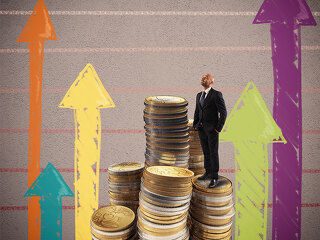 Mann-auf-Muenzstapel-Pfeile-104790879-FO-alphaspirit