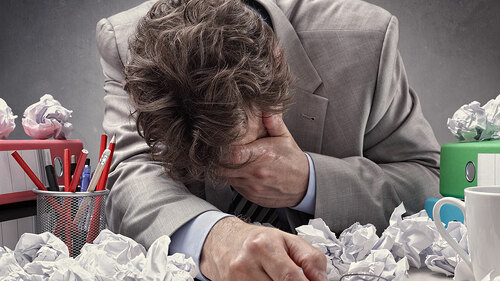 Anzugtrager-verzweifelt-zwischen-Papier-83189639-FO-Brian-Jackson