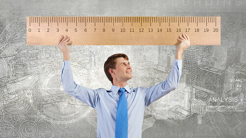 Anzugtraeger-haelt-uebergroßes-Lineal-84632365-FO-Sergey-Nivens