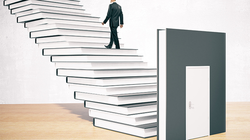 Anzugtraeger-auf-Treppe-aus-Buechern-109401454-FO-peshkov