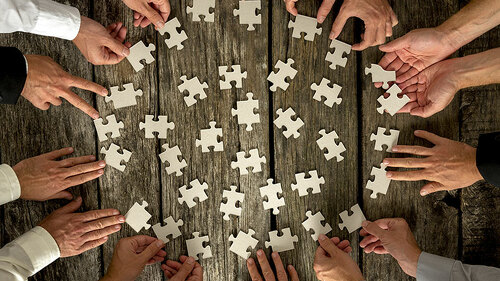 Viele-Haende-viele-Puzzleteile-90836979-FO-Gajus