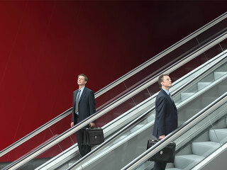 Anzugtraeger-auf.Rollreppe-72500615-FO-visivasnc